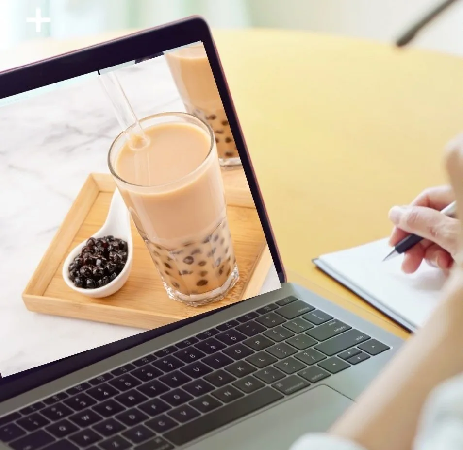 Học viên xem bài giảng pha chế trên laptop cùng ly đồ uống và sổ ghi chép