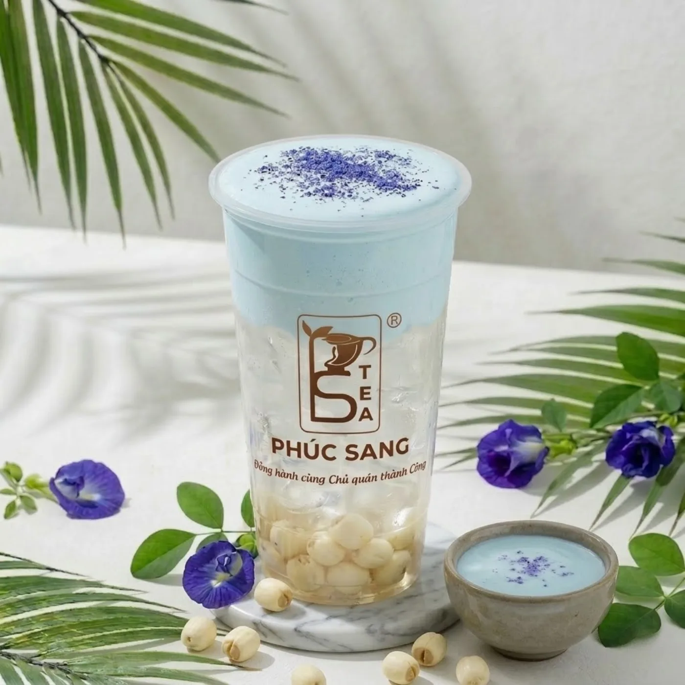 Ly nước dừa mix vị trái cây với topping trân châu, trang trí hoa đậu biếc
